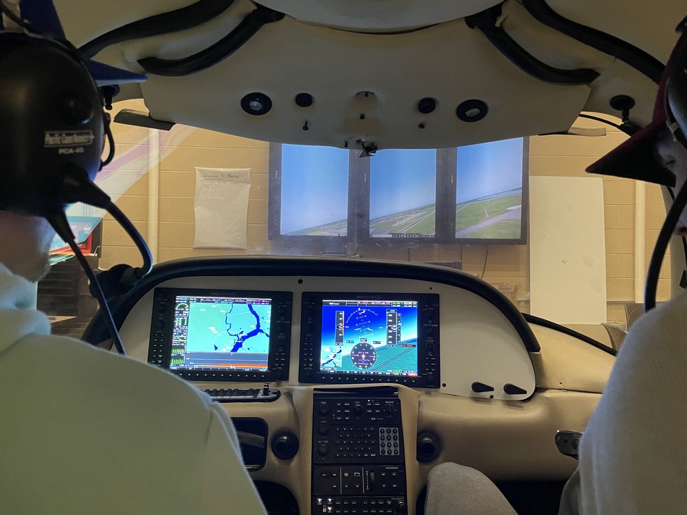 Richard Lodge (left) and Brandon Lutz (right) testing flight controls for the Cirrus SR22 flight simulator.